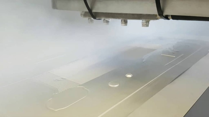 Close-up of a machine operating in a misty environment, possibly using vapor or steam on a flat surface. Close-up of a machine operating in a misty environment, possibly using vapor or steam on a flat surface.